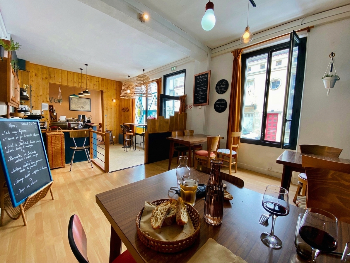 Salle du restaurant avec tables en bois, ardoise du jour et fenêtres ouvertes, cantine à Saintes